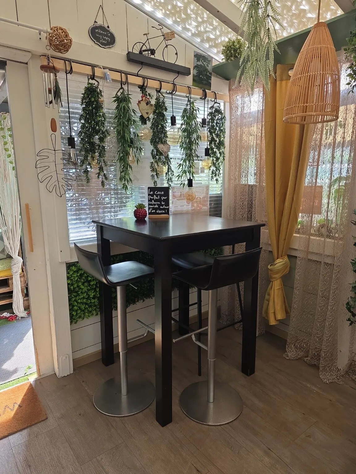 Table haute près de la verrière et des plantes